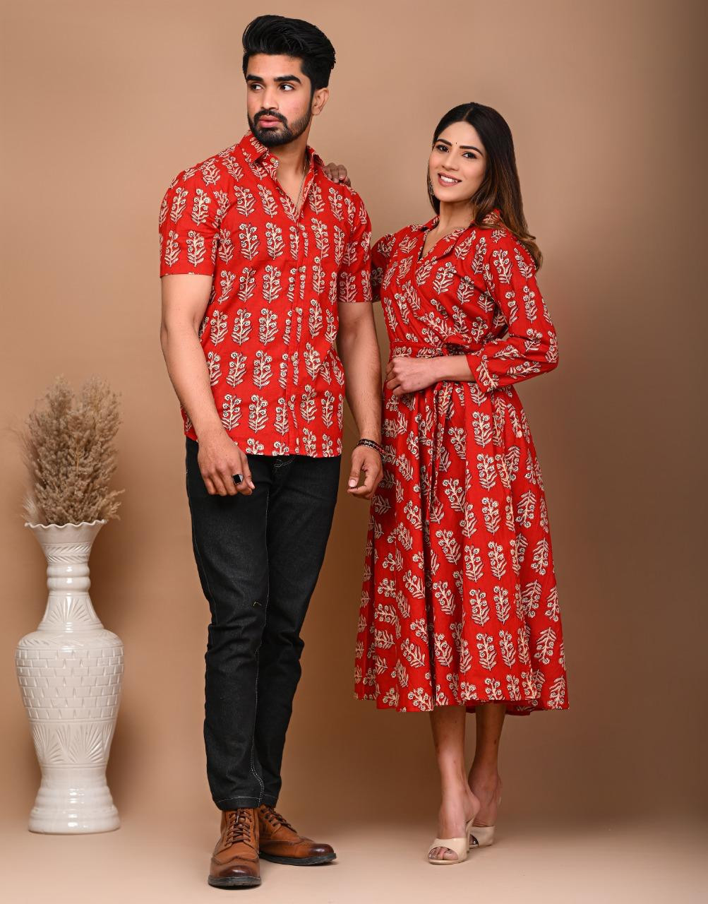 A matching couple's outfit in a red and off-white traditional hand block print design, made from a cotton material