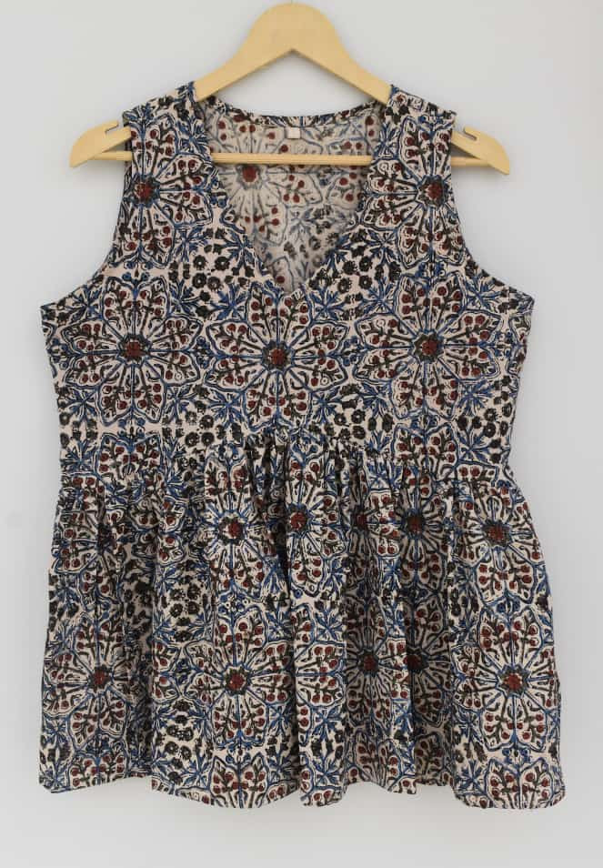 beige, blue, and reddish-brown hand-block printed, geometric or floral pattern, cotton sleeveless peplum top.