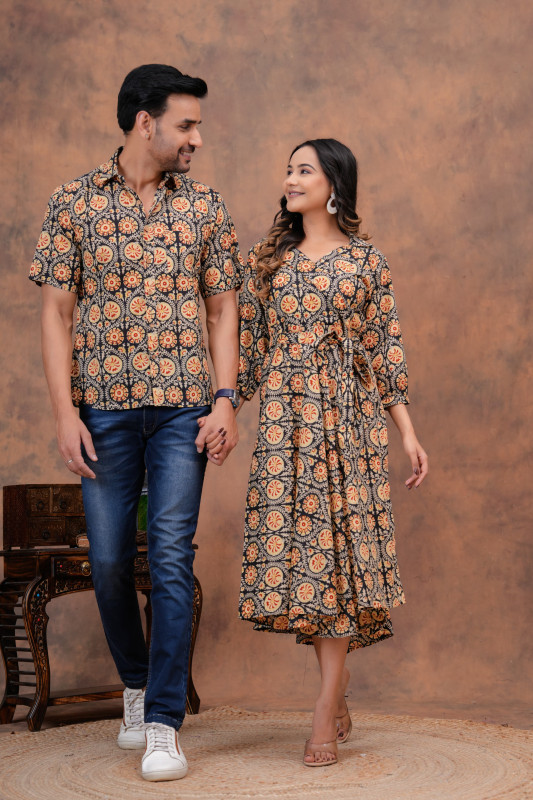a matching couple's outfit in a black and ochre traditional circular motif hand block print design, made from a cotton material
