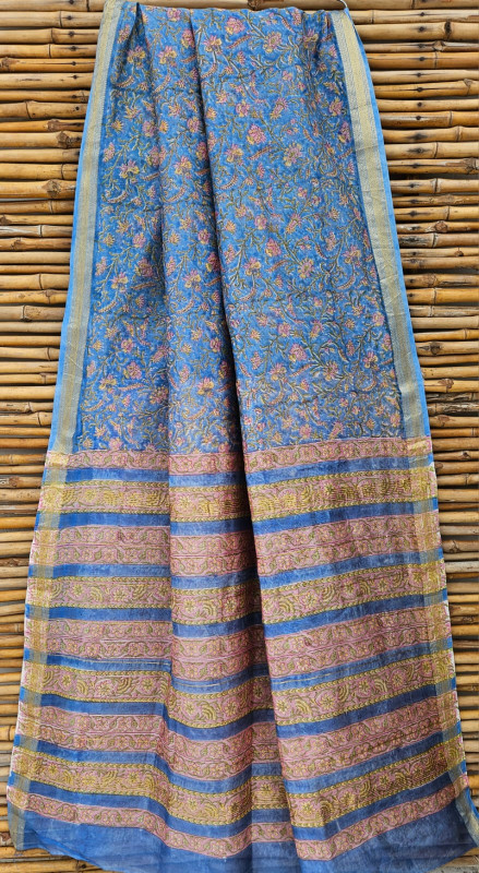 blue hand-block printed Maheshwari silk/cotton blend saree with pink and yellow floral motifs and a golden zari border.