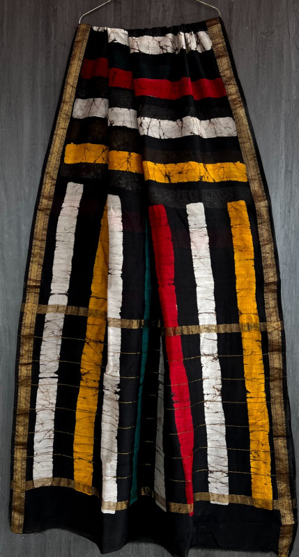 black, white, yellow, and red hand-block printed Maheshwari silk/cotton blend saree with striped and traditional motifs and a golden zari border.
