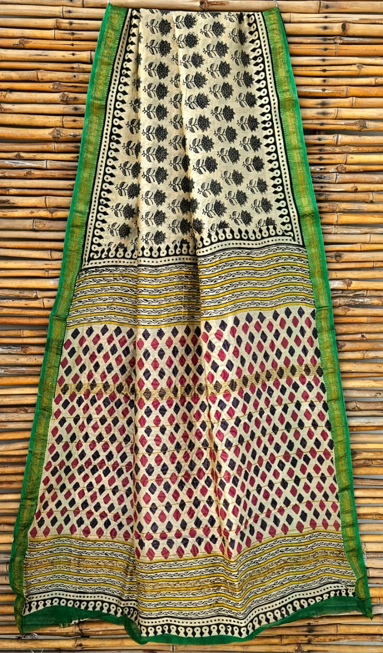 beige, red, and black hand-block printed cotton or silk-cotton blend saree with a green border.