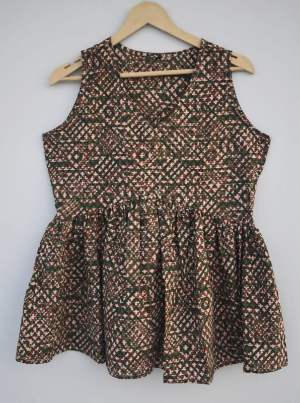 green and reddish-brown, hand-block printed, geometric pattern cotton sleeveless peplum top.
