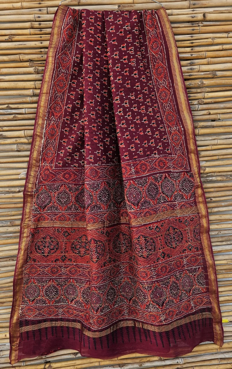 maroon Maheshwari silk/cotton handloom saree with a golden zari border and traditional hand-block printing, possibly Ajrakh print.