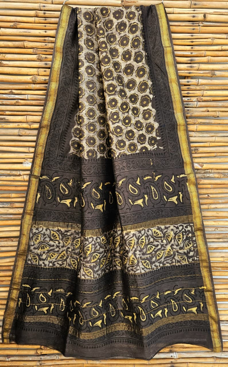 black and beige hand-block printed Maheshwari or Chanderi silk/cotton blend saree with traditional and floral motifs and a golden zari border.